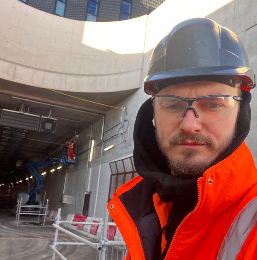 Alexandru Plestiu, Director of ALP Construct, on site in hard hat, safety glasses and hi-vis